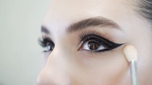 Maquilleur appliquant le maquillage des cils sur l'œil du mannequin.
Voir