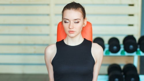 Sporty Young Woman Exercising with Dumbbells in the Gym