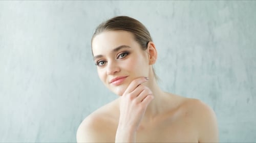 Beautiful Woman Posing and Touching Her Healthy Skin and Bare Shoulders. Skincare Concept