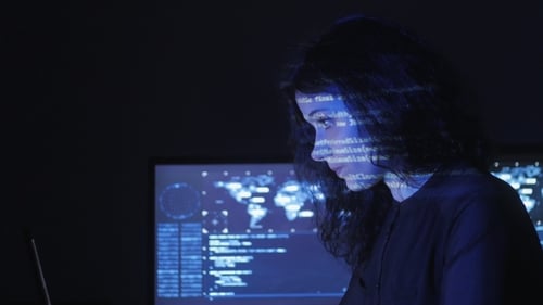 Portrait of Young Woman Programmer Working at a Computer in the Data Center Filled with Display