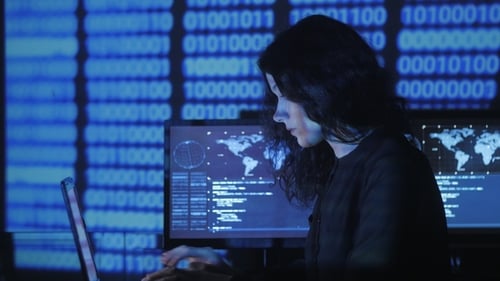Retrato de una joven programadora que trabaja en una computadora en el centro de datos llena de pantalla