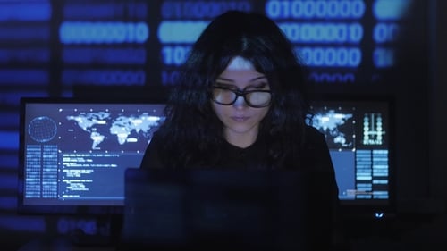 Bespectacled Woman Hacker Programmer Is Working on Computer in Cyber Security Center
