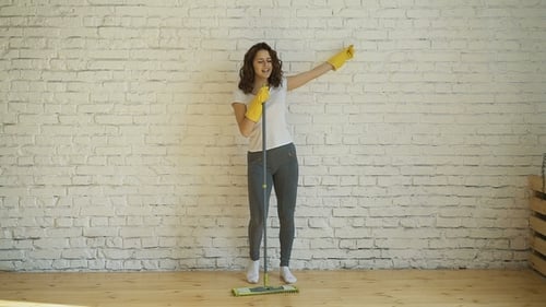 Woman Dances with Mop in Living Room