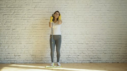 Woman Dancing with Mop in Bright Room
