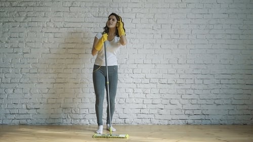 Woman Dancing and Cleaning with Mop and Headphones