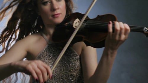 Woman Playing Violin Elegantly in Dramatic Lighting