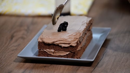 Chocolate Cake Being Decorated with Spoon