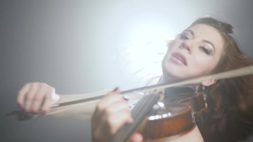 Beautiful Woman Plays Violin with Creative Lighting