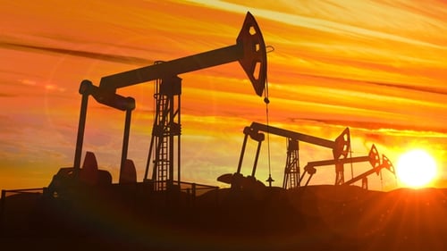 Silhouetted Oil Pumpjacks Working Against a Vibrant Sunset Sky