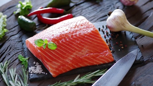 Raw Salmon Fillet with a Basil Leaf.