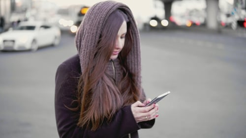 Jovem usa um smartphone na cidade