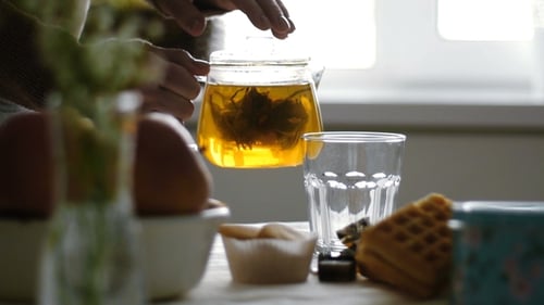 Tea Being Poured Into Glass with Pastries