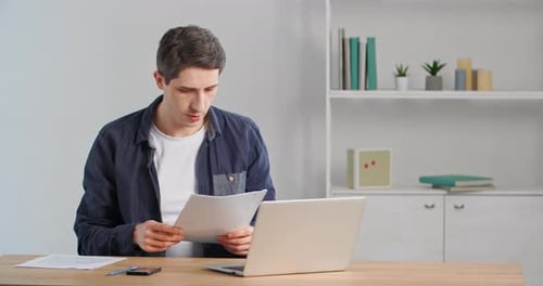 Concentrated Caucasian Male Freelancer Man Adult Guy Sitting at Table at Home Office Looking in