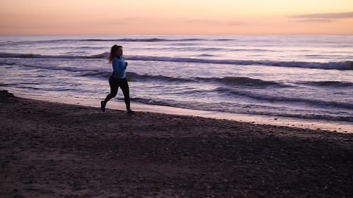 Woman Running In The Beach At Sunset