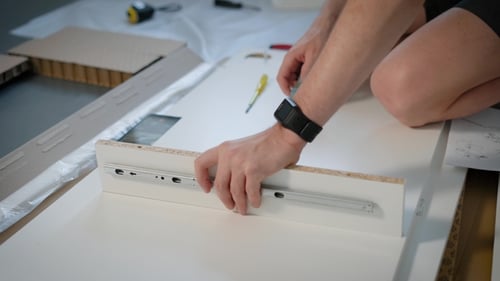 Foto de un manitas montando con éxito una nueva mesa en casa.