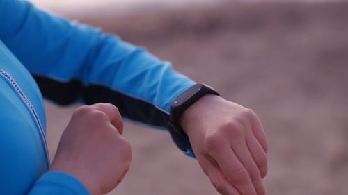 Woman Uses Smartwatch on Beach, Close Up