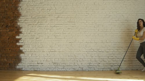 Woman Dancing While Cleaning Home With Mop