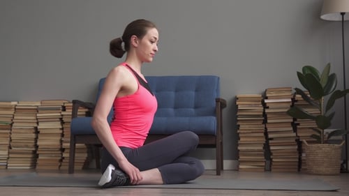 Woman Stretching on Yoga Mat in Home Setting