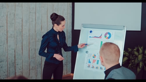 Woman Presents Data to Colleagues in Meeting