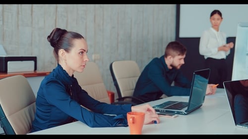 Geschäftsleute sitzen an einem Tisch und diskutieren einen Geschäftsplan, während eine schöne Frau