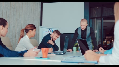 Boss Standing Near a Table and Discussing a Business Plan with Co-workers in the Office
