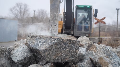 el constructor se sienta al volante del tractor, con el que puede romper las piedras en partes