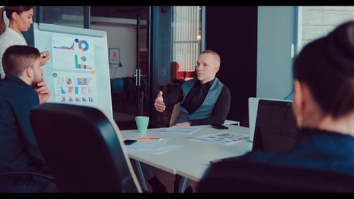 Executive Director Tells New Ideas To Her Colleagues, While the Girl Stands Near the Flipchart and