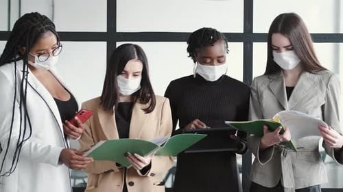 Business Women Reviewing Documents Wearing Facemasks