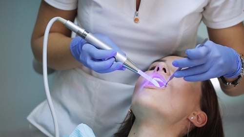 Dentist Performing Dental Procedure on Woman