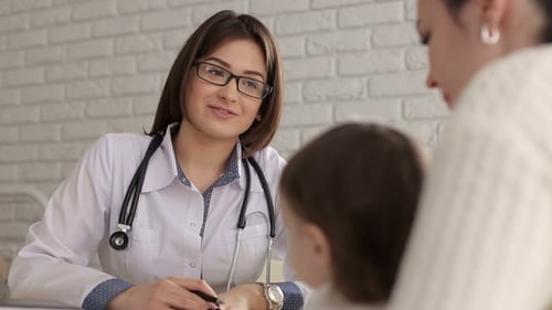 Friendly Doctor Talking With Mother and Child