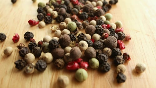 Mixed Peppercorns Poured onto a Wooden Surface