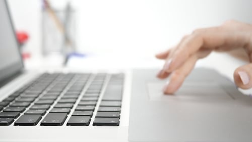Woman's Hand Using Laptop Trackpad in Office