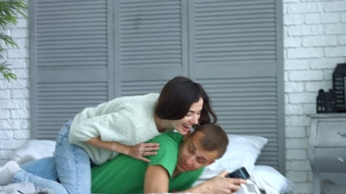 Loving Woman Embracing Her Man in Bed at Home