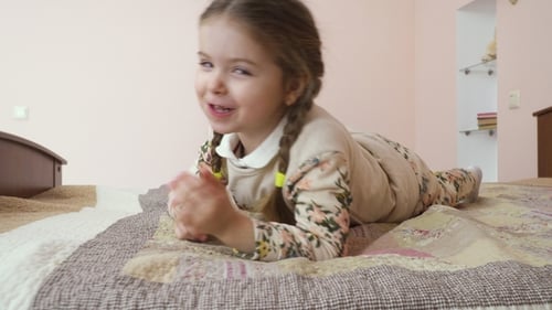 Little Girl Lying on Bed Smiling