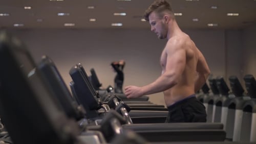 Man Exercising on Treadmill in Modern Gym