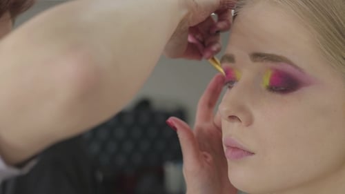 Makeup Artist Applying Colorful Eyeshadow to Young Woman