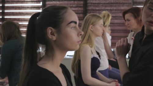 Makeup Artists Apply Cosmetics to Clients in Studio