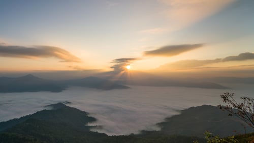 Sunrise Over Mountains Covered in Clouds