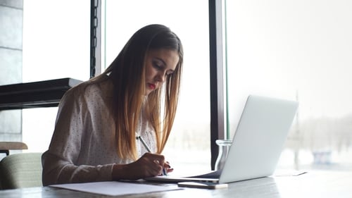 Geschäftsfrau arbeitet mit Laptop und prüft die Dokumente