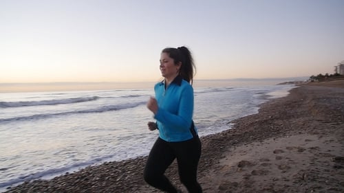Fitness Woman Runner Running on the Beach