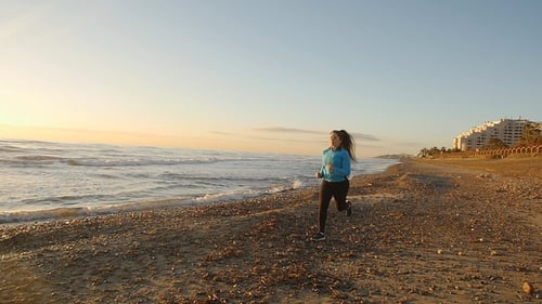 Fitness Woman Runner Running on the Beach