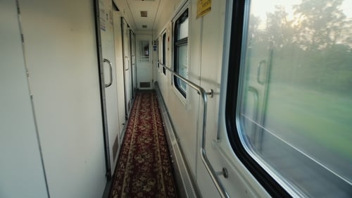 Couloir d'une voiture de chemin de fer confortable. Le train se déplace rapidement, la caméra se déplace le long du