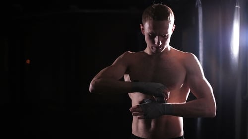Male Boxer Wraps Her Hands In Boxing Gym