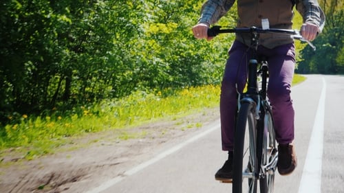 Man with Beard Rides Bike Through Forest