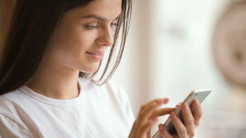 Woman Using Smartphone with a Smile Close Up