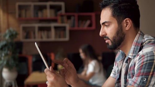 Young Adult Works on Tablet in Office