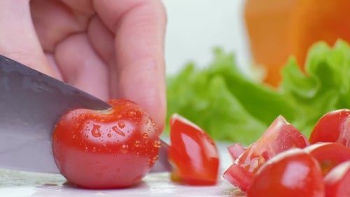 Cutting Fresh Cherry Tomatoes on White Cutting Board