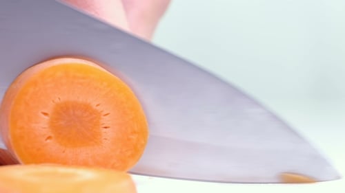 Knife Slicing Carrot into Round Pieces