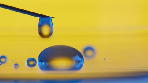 Transparente Wassertropfen aus einer Spritze bilden einen kleinen Pool
