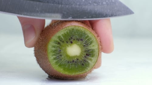 Cutting Slices of Green Kiwi Fruit